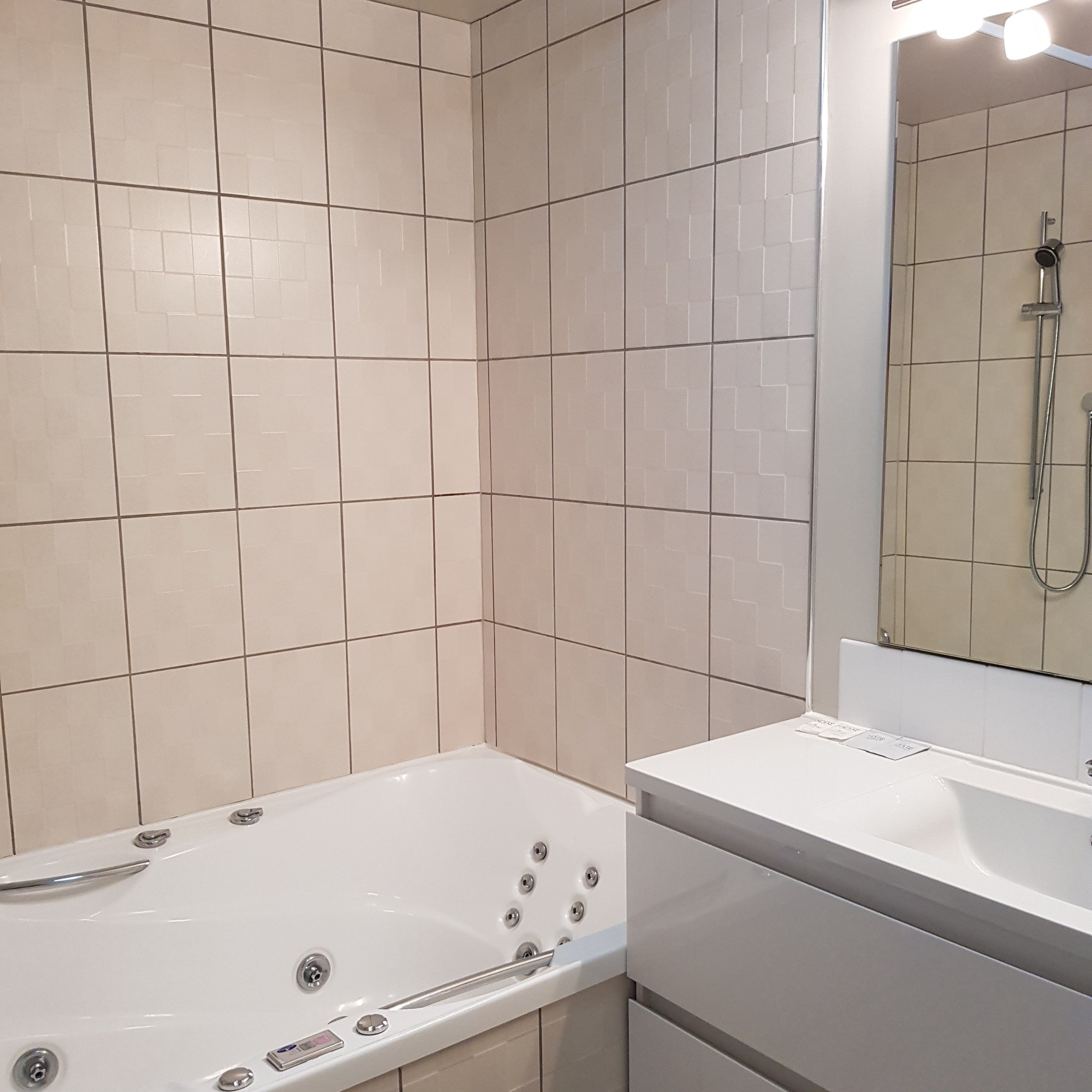 A modern bathroom with a bathtub, a sink, and a shower.