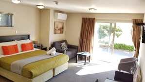 Een hotelkamer met een bed, een bank, een tafeltje en een raam met gordijnen.