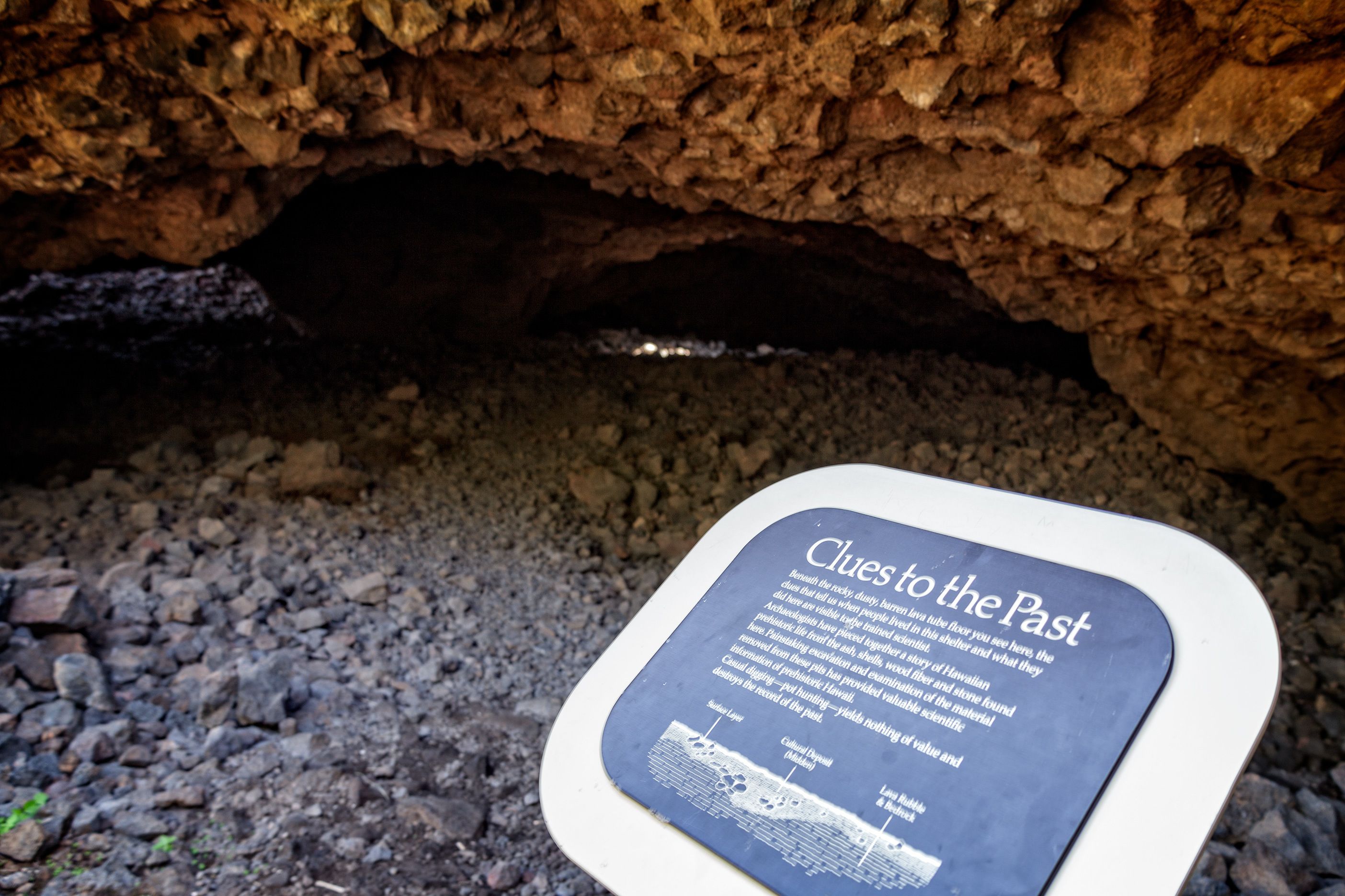 A cave entrance with a sign titled 'Clues to the Past'.