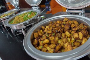 A buffet with various dishes, including fried potatoes and a rice dish.