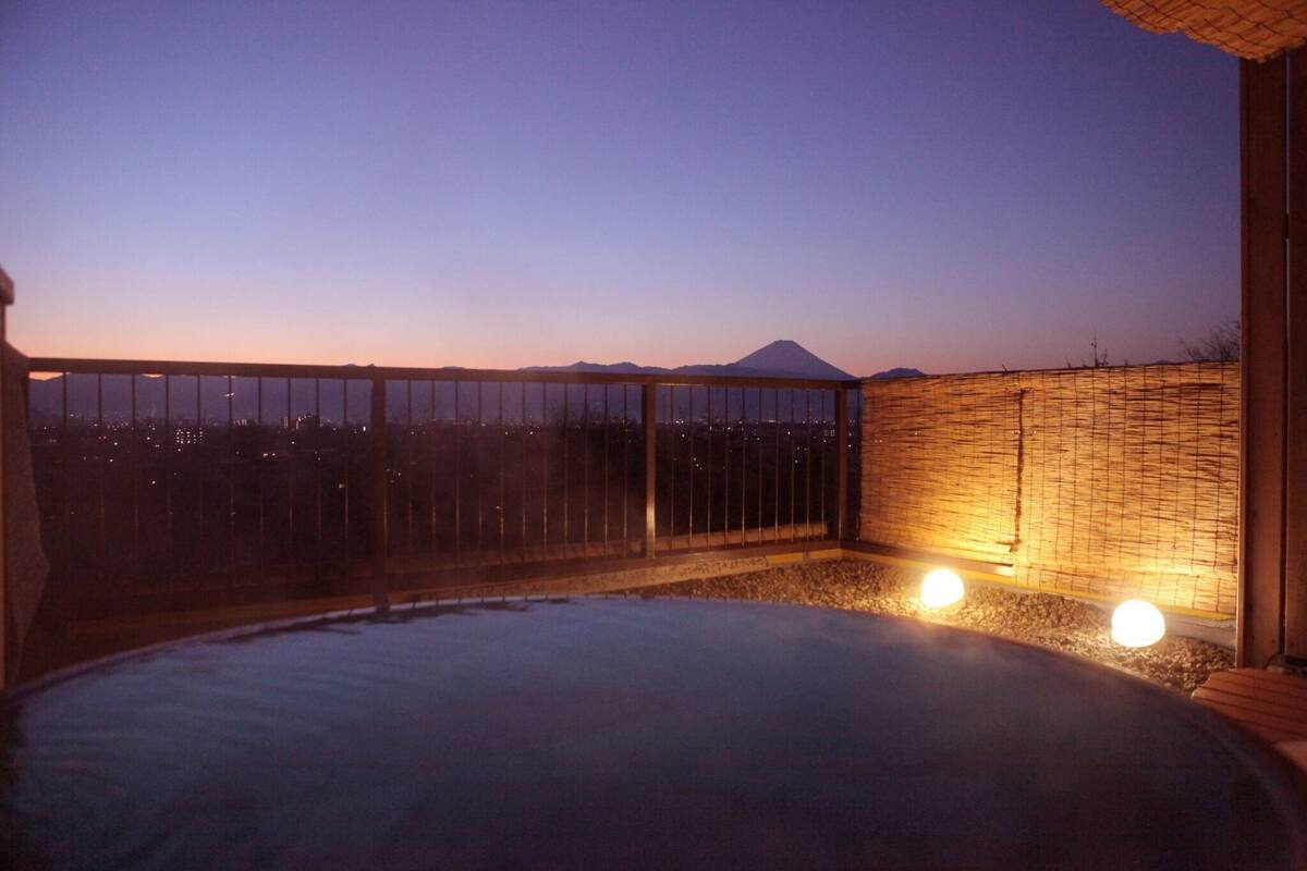 A hot tub with a view of a mountain at dusk.
