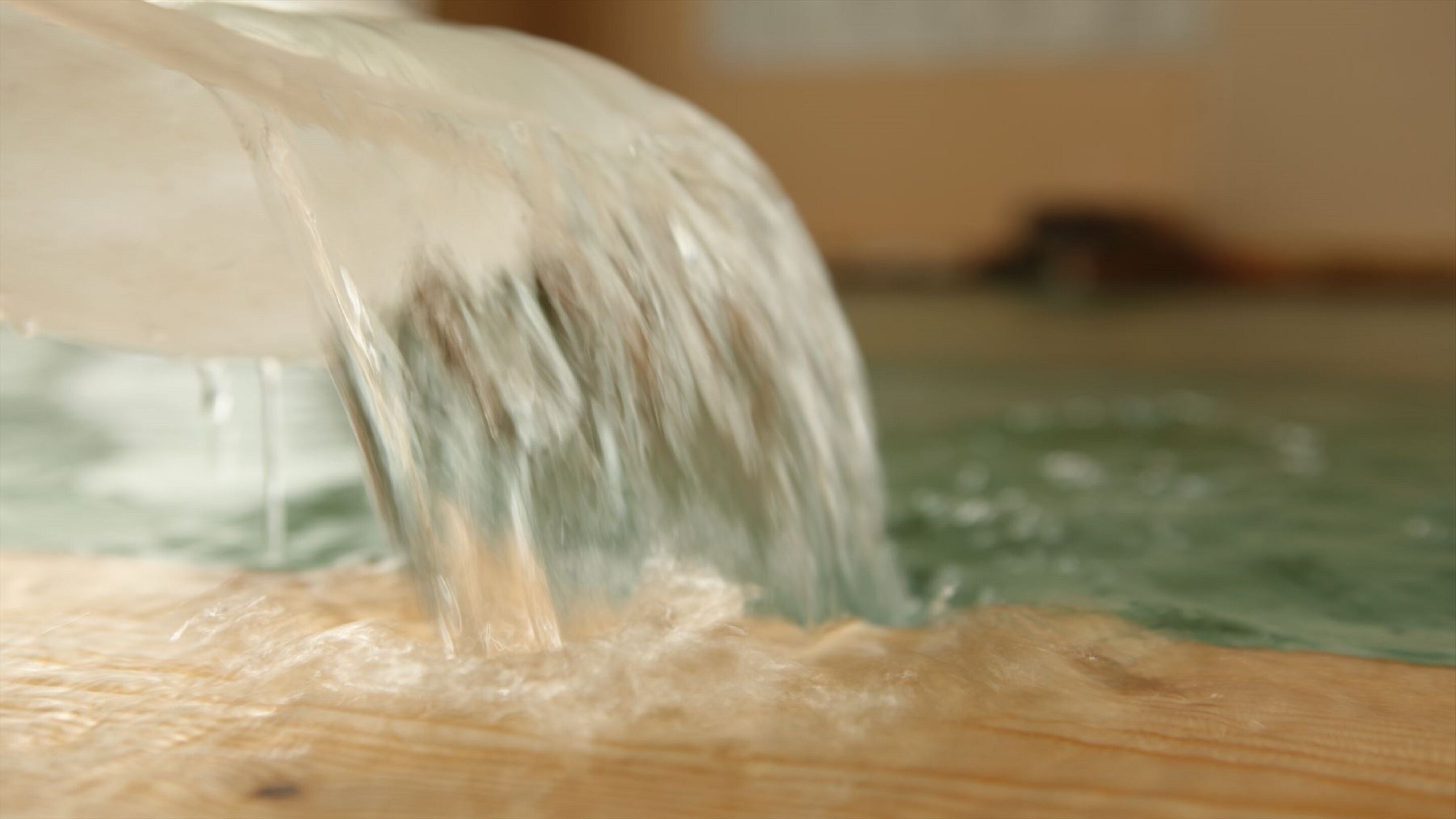 A close-up of a wooden surface with a liquid being poured onto it.