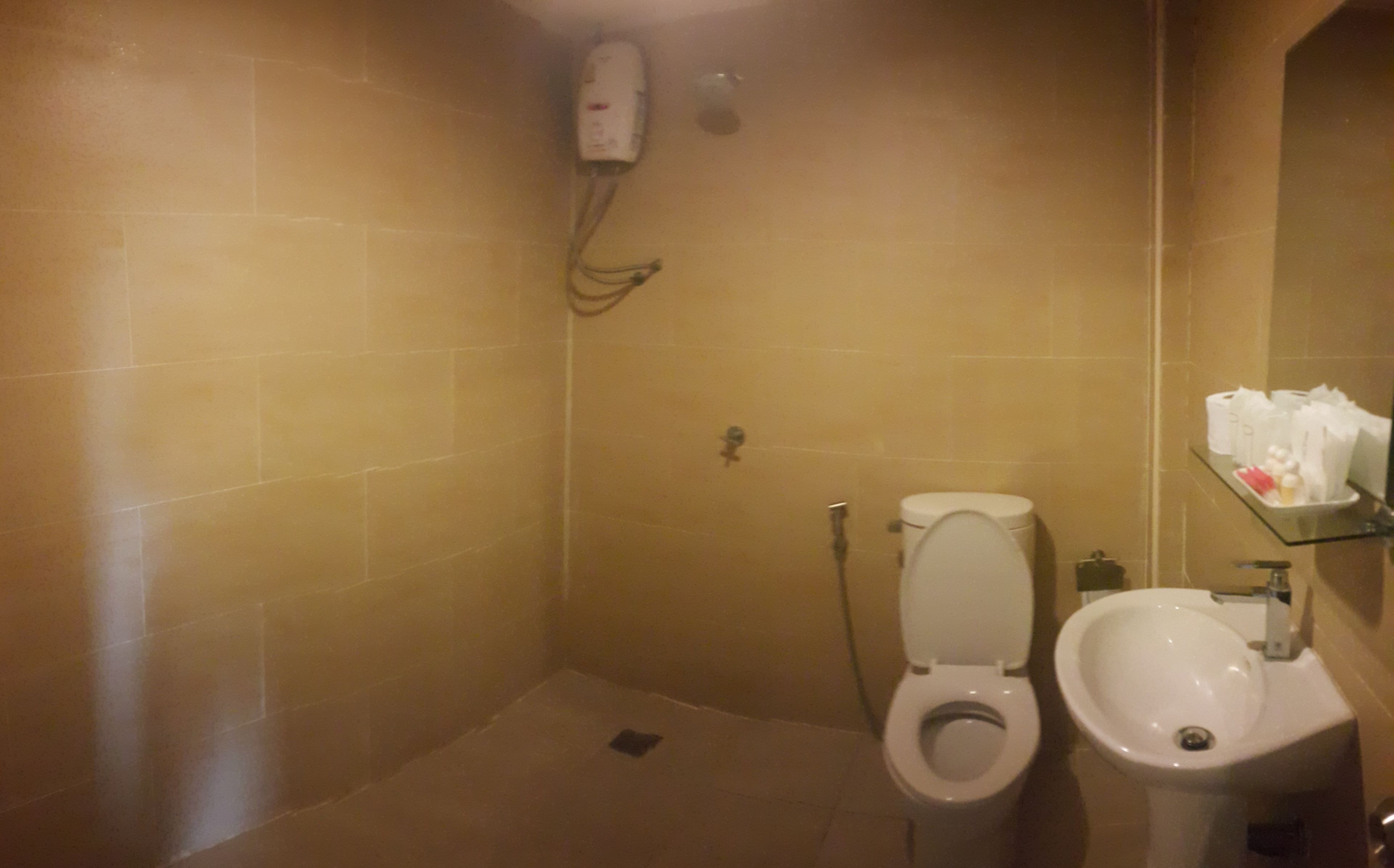 Un baño con inodoro, bidé y un lavamanos pequeño.