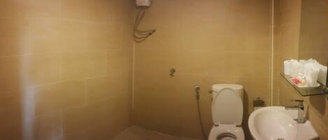 Un baño con inodoro, bidé y un lavamanos pequeño.