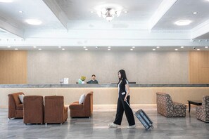 A hotel lobby with a reception desk, seating area, and a chandelier. - Windmill Resort Hotel (Pattaya)