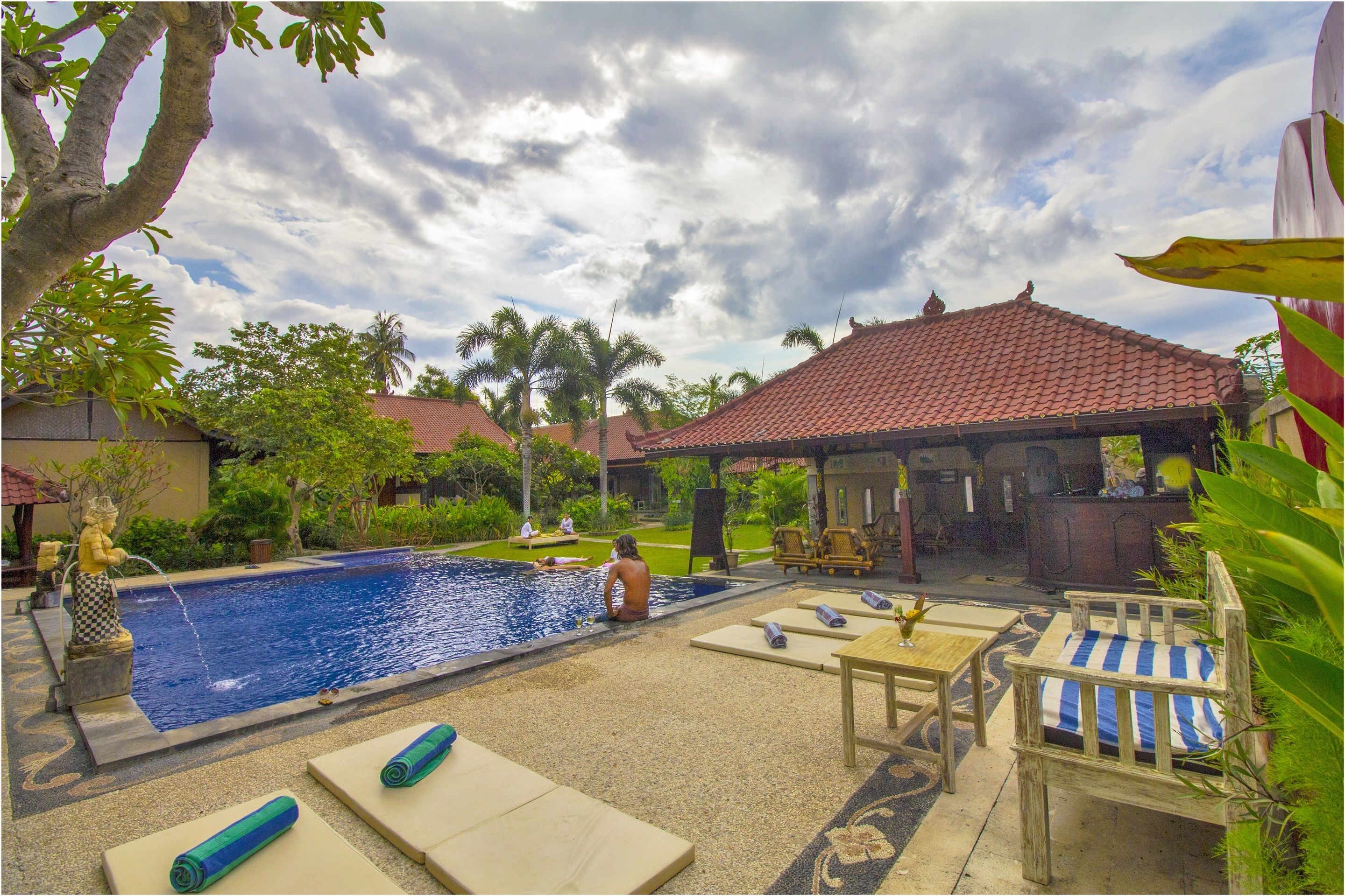 Area piscina con lettini e un gazebo.