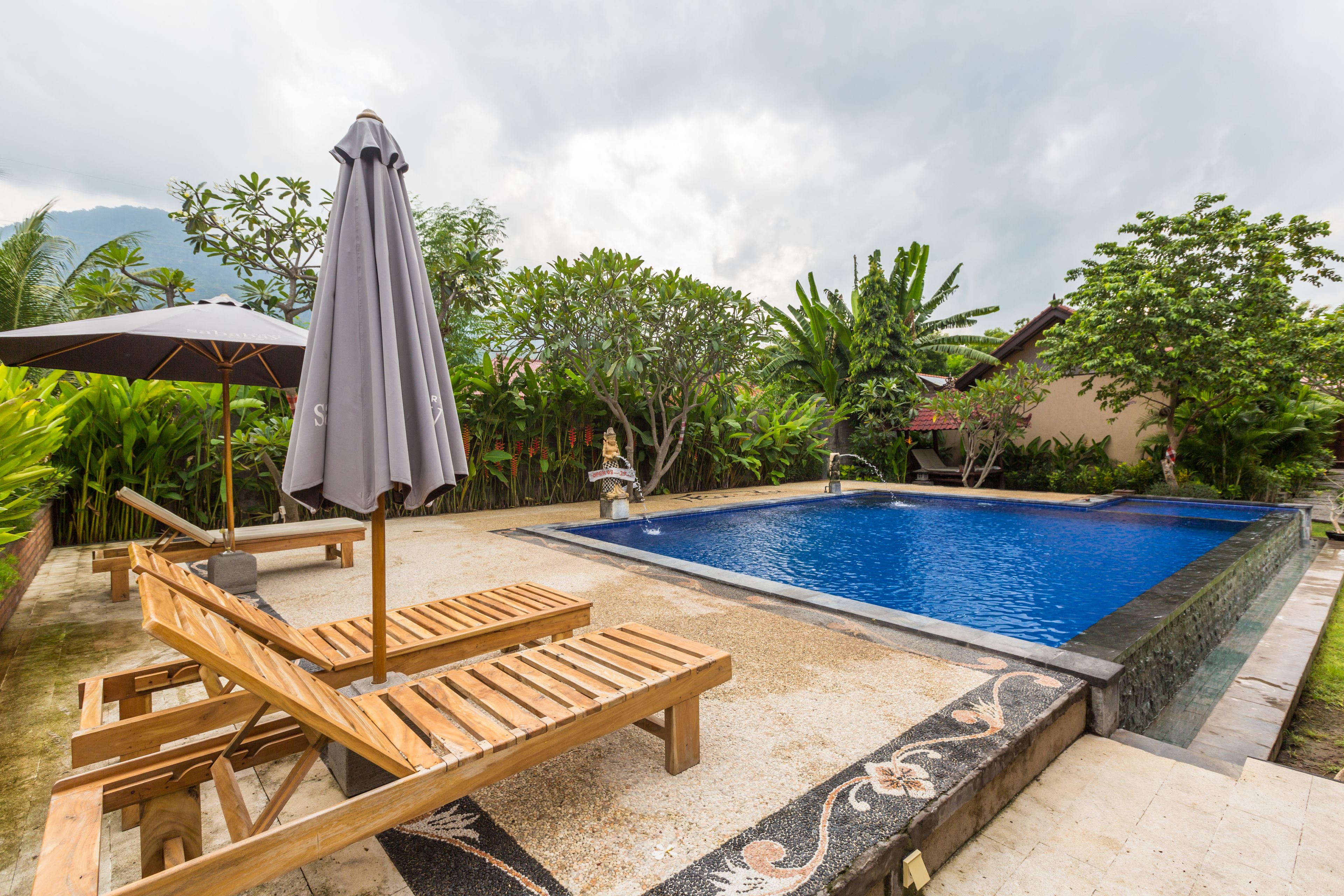 Una piscina al aire libre, sillones reclinables de piscina