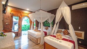 A room with two beds, each with a canopy, a brick wall, and a wooden floor.