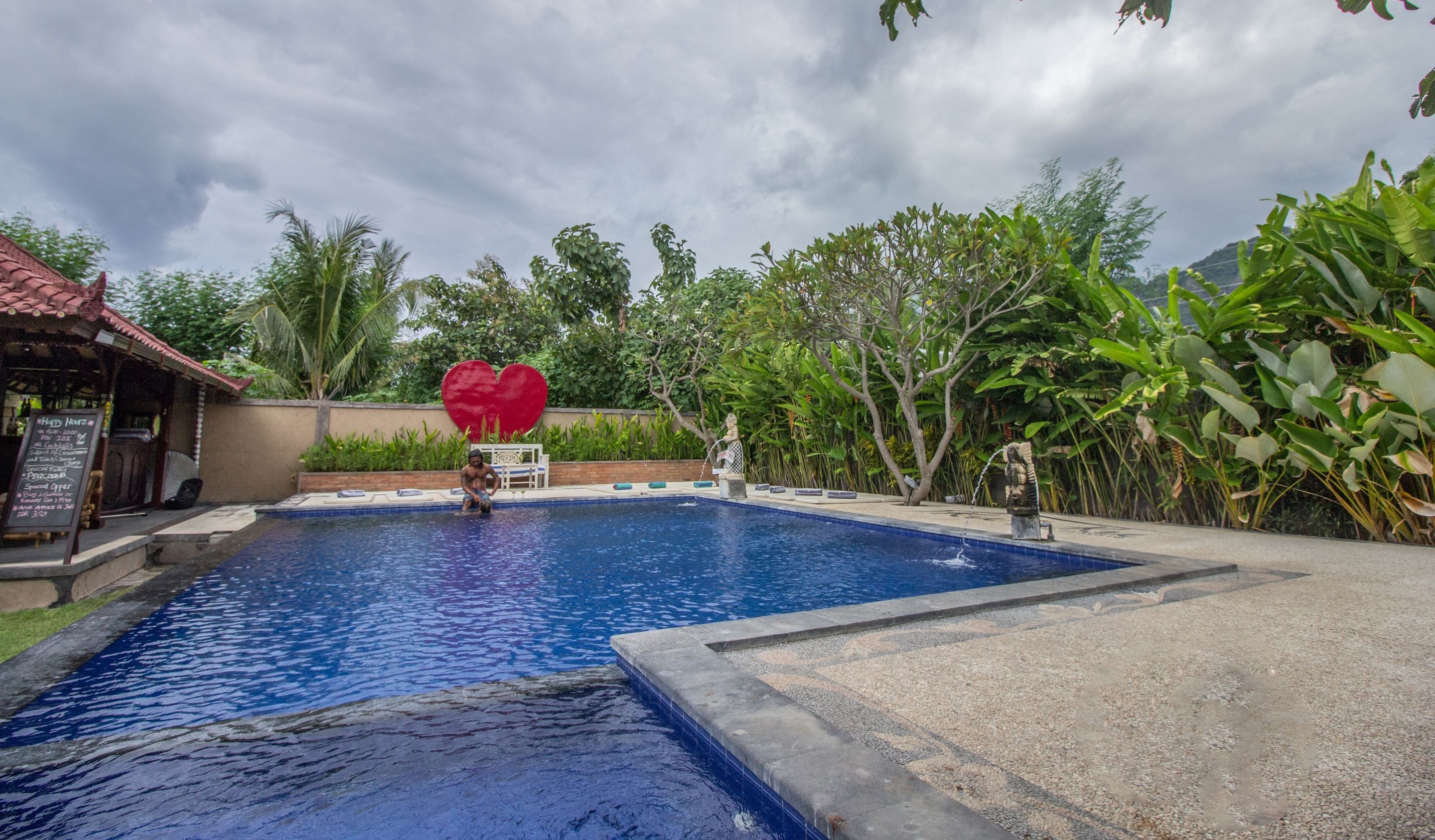 Una piscina con una estatua y un adorno con forma de corazón.