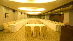 Uma sala de conferências com uma mesa comprida, cadeiras e um púlpito.