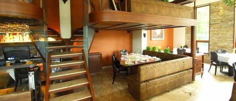 A modern interior with a wooden staircase, a dining area, and a bar.