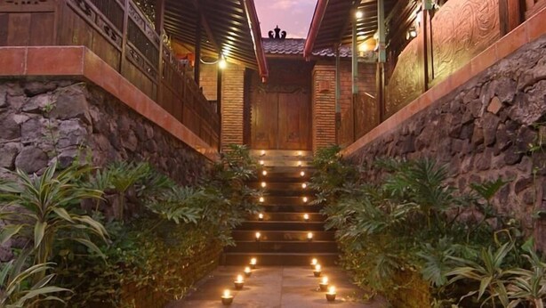A stone staircase leading to a wooden door with a decorative ceiling. - Joglo Plawang Boutique Villa (Pakem)
