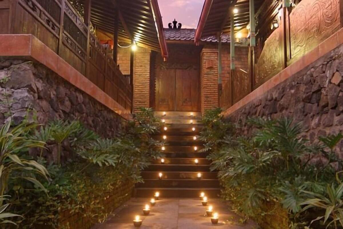 A stone staircase leading to a wooden door with a decorative ceiling.