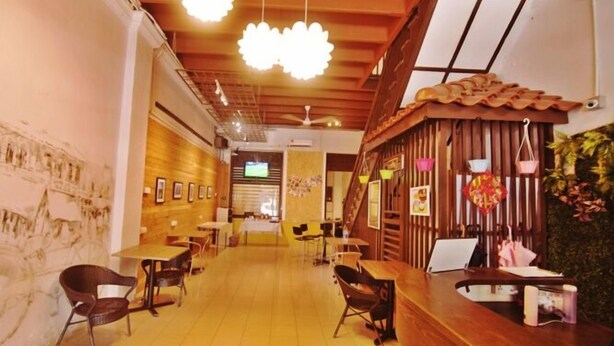 L’intérieur d’un restaurant présente des éléments décoratifs en bois, un comptoir d’accueil et des chaises disposées pour les repas.