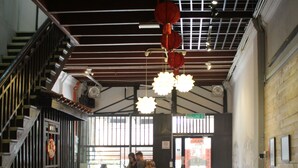 Un espace intérieur comprenant un comptoir d’accueil, un coin salon et un escalier.
