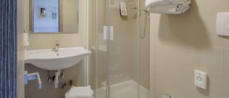A modern bathroom with a glass-enclosed shower, a sink, a bidet, and a toilet.