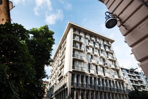 A multi-story building with balconies, a clear sky, and a tree in the foreground. - Sure Hotel by Best Western Nologo (Genoa)