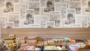 Een buffet met diverse gerechten en een muur versierd met krantenknipsels.