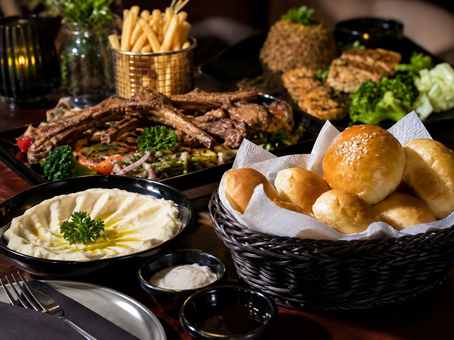 A table with various dishes including meat, vegetables, and bread.