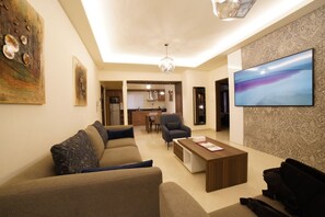 A modern living room with a sofa, coffee table, and artwork on the walls.