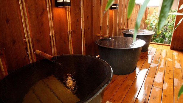 Un onsen japonés tradicional con paredes de madera y grandes tinas termales.