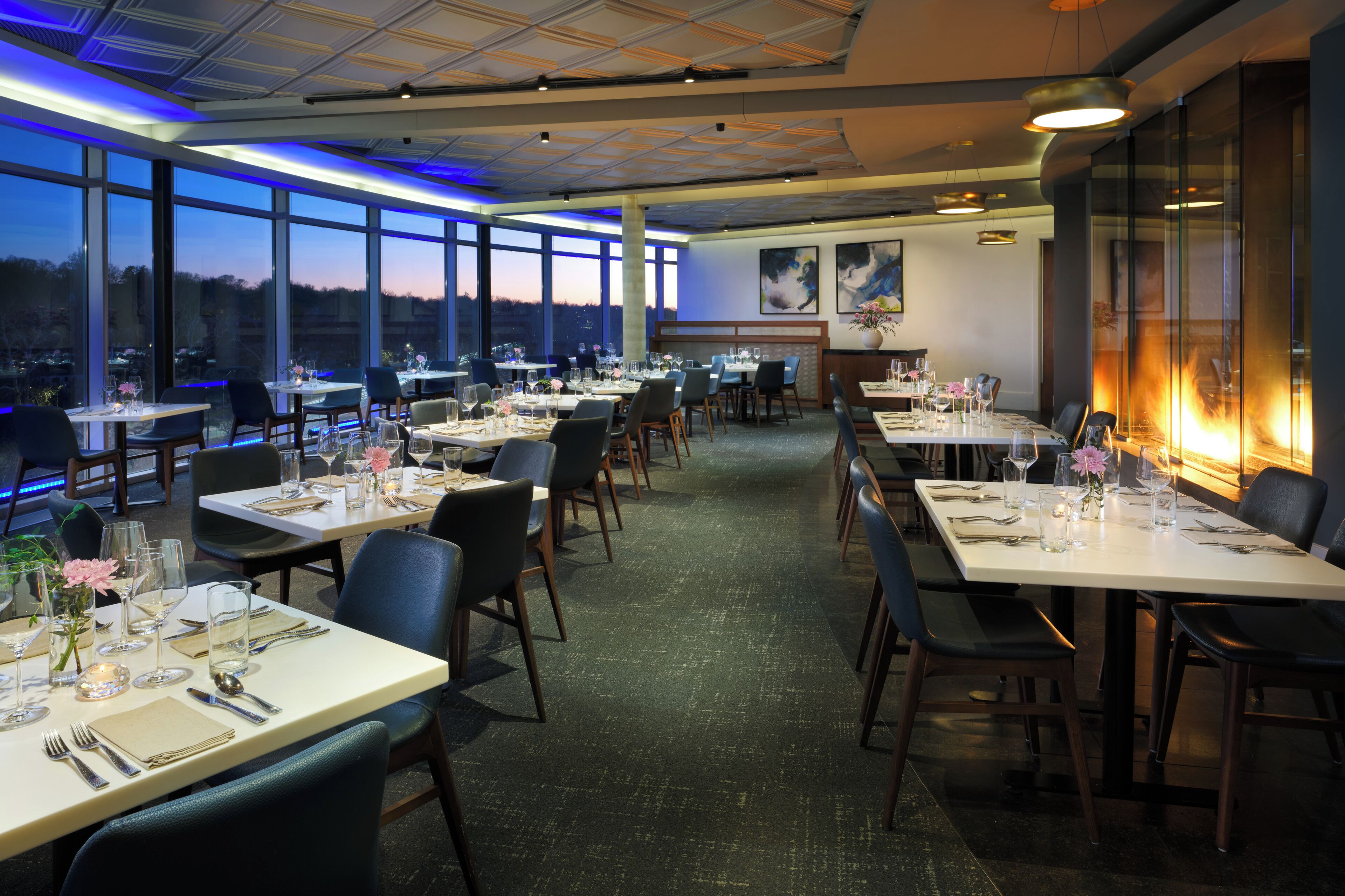 A restaurant with multiple tables, chairs, and a view of the outdoors.