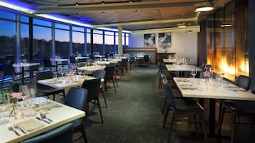 A restaurant with multiple tables, chairs, and a view of the outdoors.