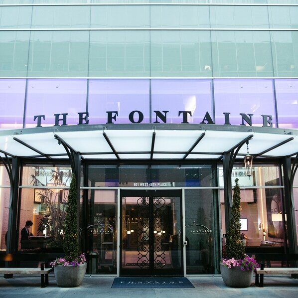 The entrance to The Fontaine hotel with a glass facade and a sign above the doors. - The Fontaine (Kansas City)