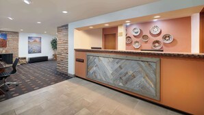 A reception area with a herringbone-patterned wall, a herringbone-patterned floor, and a herringbone-patterned reception desk. - Best Western Red Hills (Kanab)