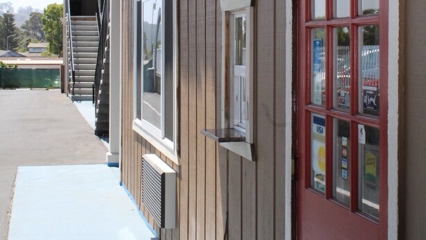 A building with a sign that reads "OFFICE" above a red door. - BeachWay Inn (Arroyo Grande)