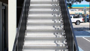 A staircase with metal railings leading to an entrance. - BeachWay Inn (Arroyo Grande)