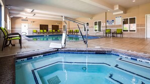 Un espace piscine doté de plusieurs couloirs de nage, de rampes de sécurité et de chaises longues.
