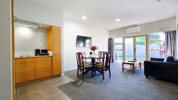 A modern kitchen with wooden cabinets and a dining area with a table and chairs.