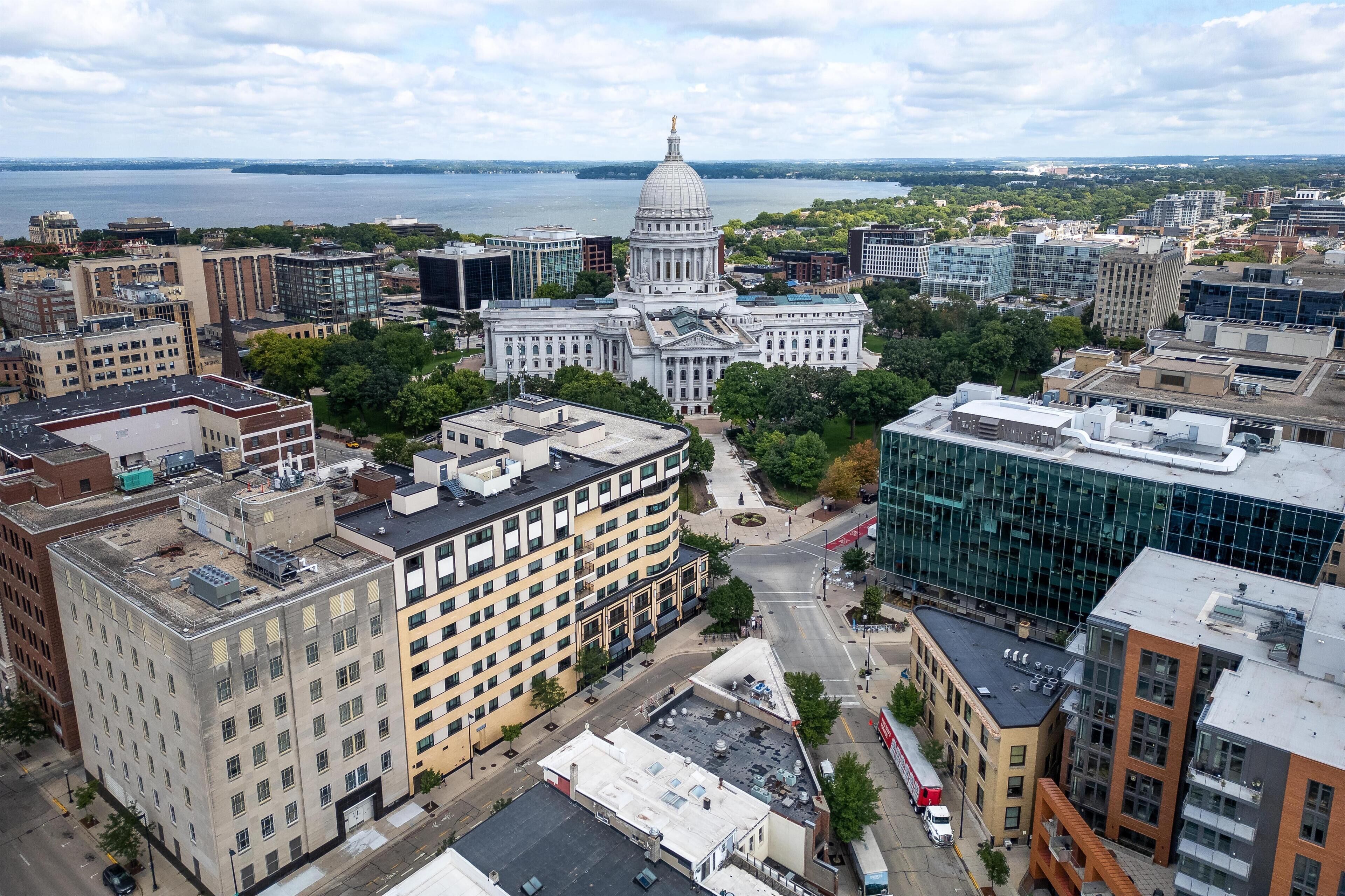 A cityscape with a prominent government building, modern buildings, and a waterfront.