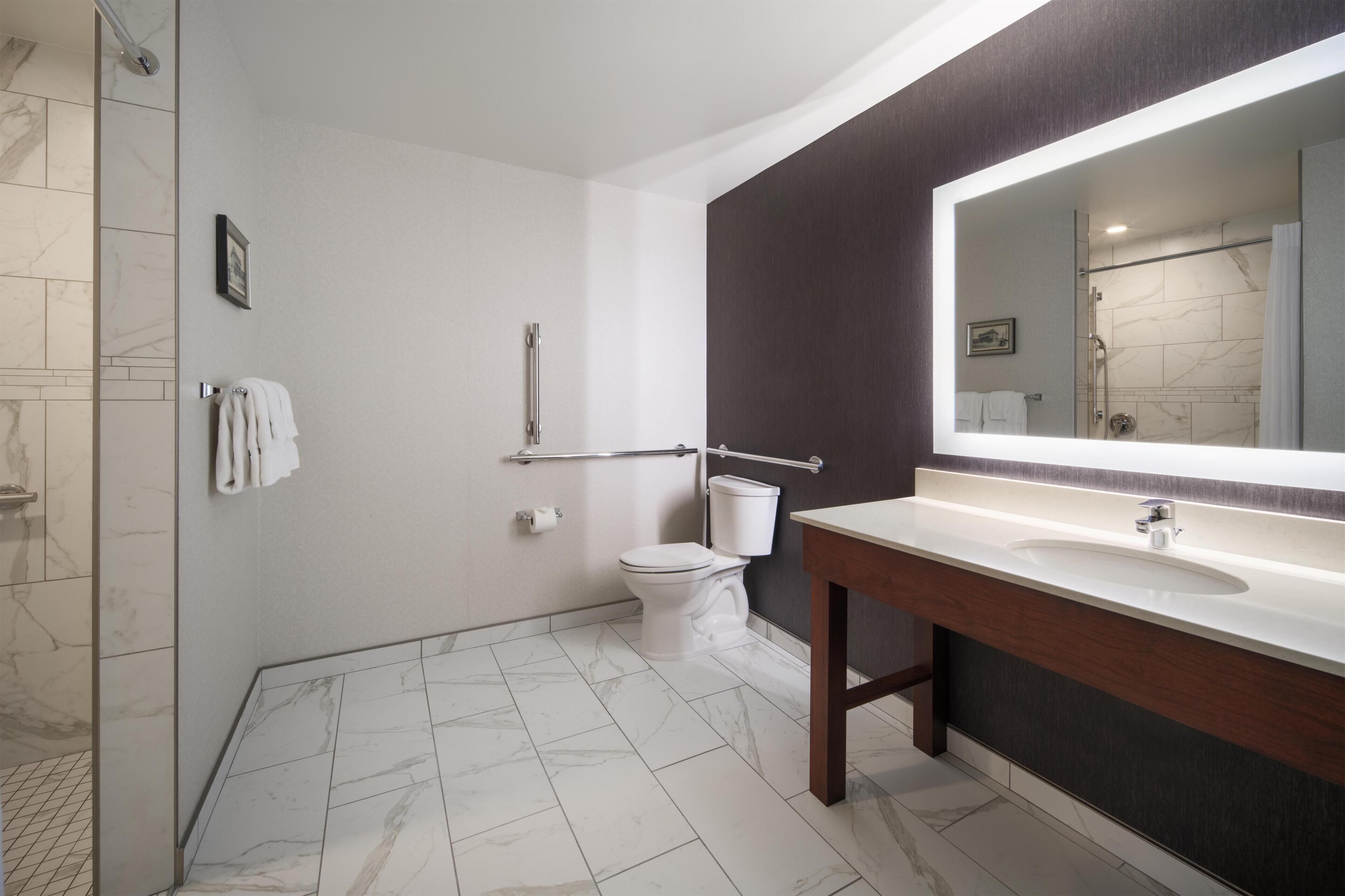 A bathroom with a shower, toilet, and sink.
