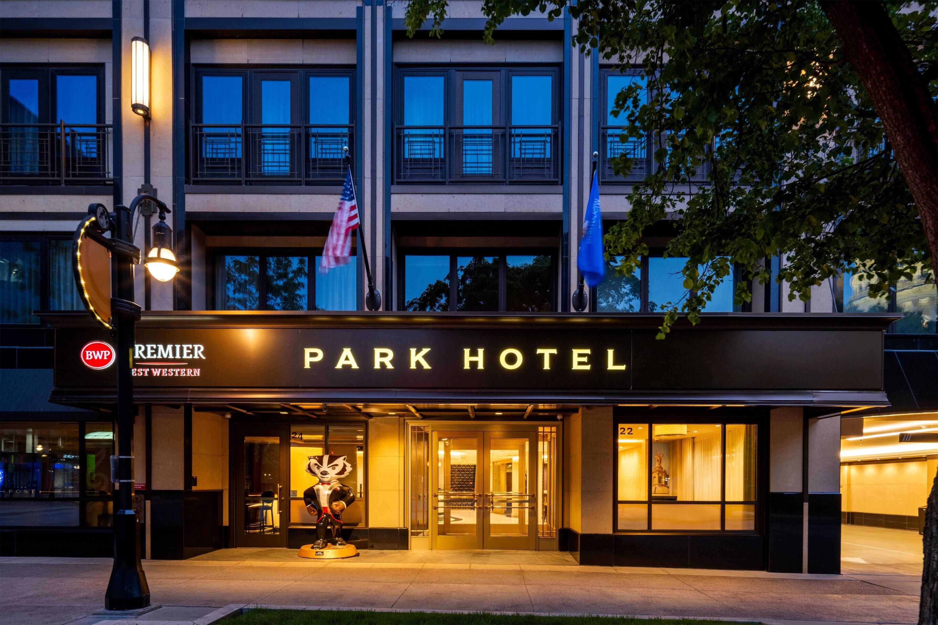 The exterior of the Park Hotel with a prominent entrance, American flag, and a mascot statue.