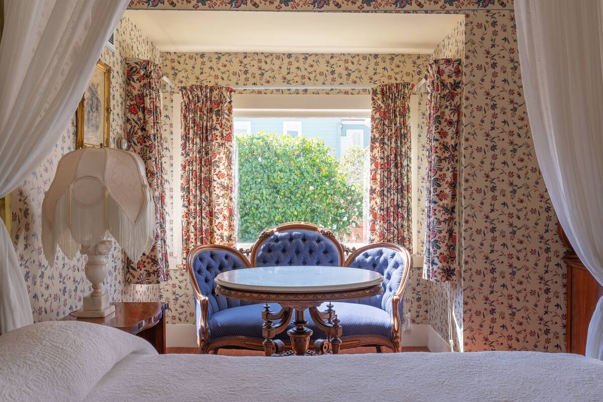 Ein Schlafzimmer mit einem Bett, einem runden Tisch und einem Stuhl.