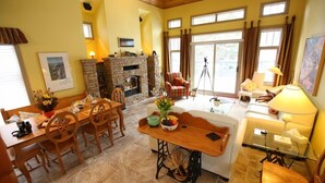 A cozy living room with a fireplace, dining area, and seating. - Buffaloberry B&B (Banff)