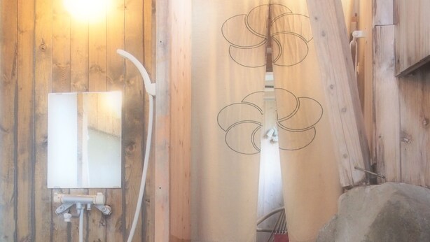 Eine Holzhütte mit Sauna, Spiegel und Handtuchhalter.