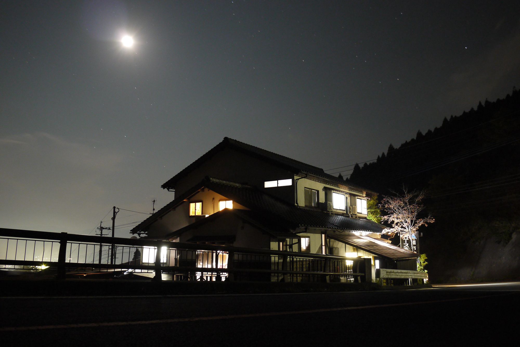 Un bâtiment à deux étages doté d’un balcon, de fenêtres illuminées et d’une enseigne bien visible.