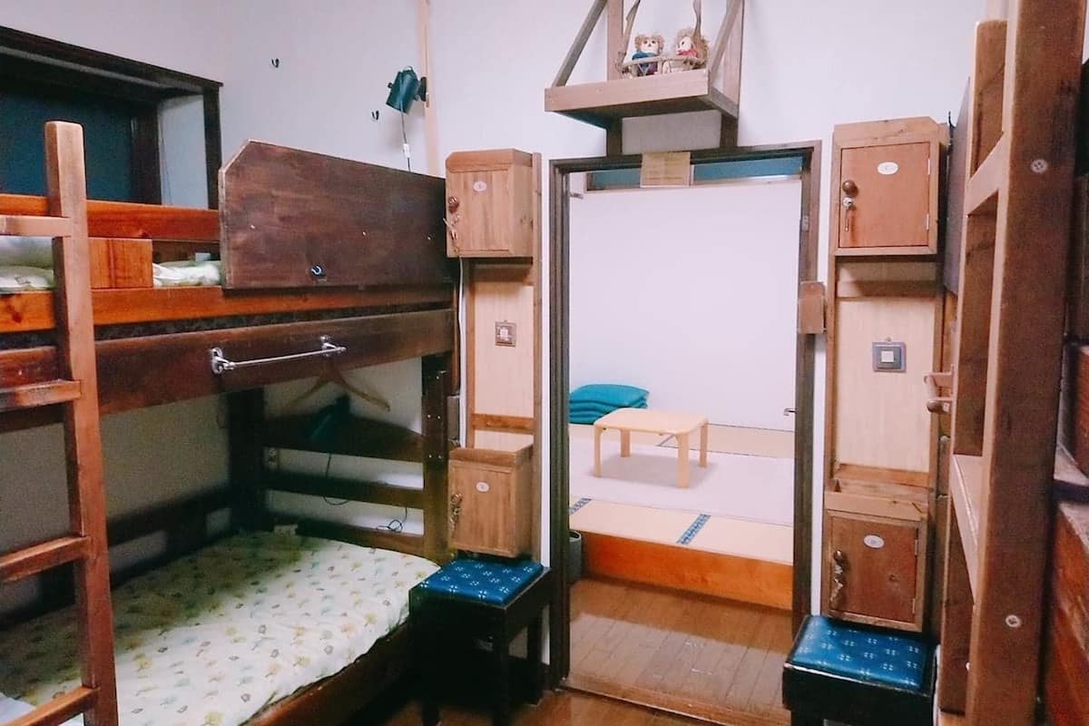 Une chambre de dortoir avec des lits superposés, un petit bureau et une chaise.