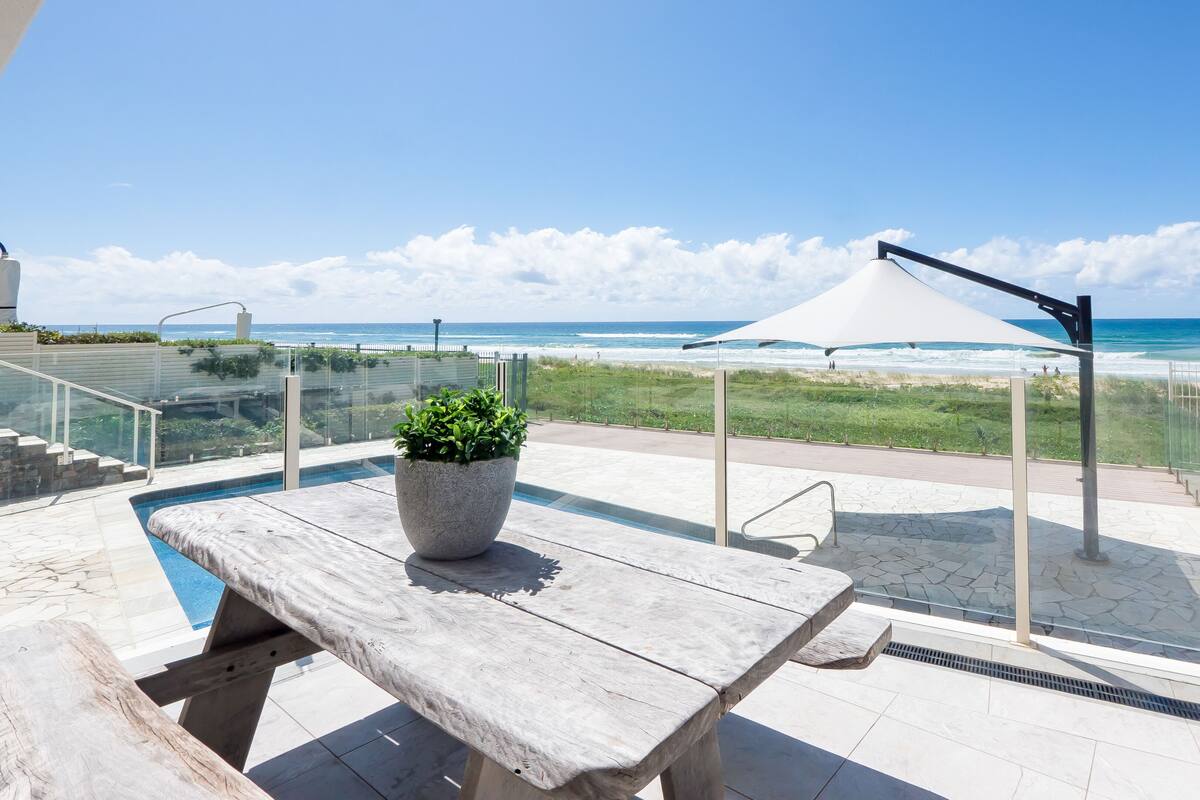 A poolside area with a view of the beach and ocean.