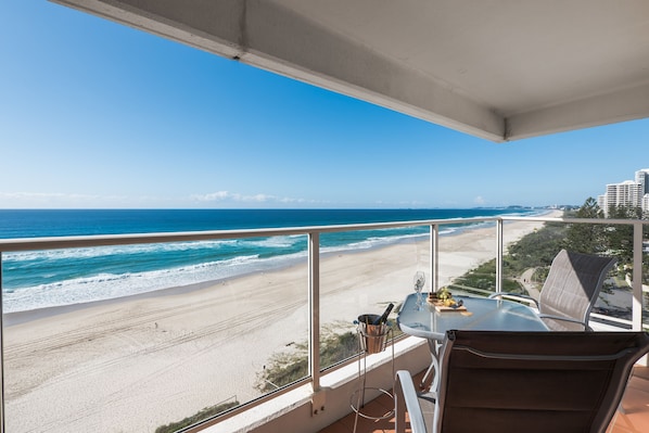 A balcony with a clear view of the beach and ocean.
