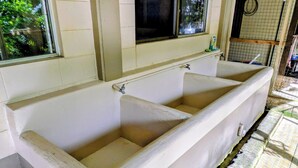 A bathroom with two sinks, a window, and a tiled wall. - DW Motel Palau (Koror)