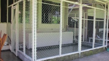 A fenced outdoor area with a bench and a table.