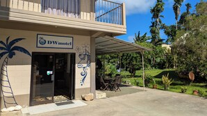 A two-story building with a balcony, a sign reading "DW Motel," and a tropical mural. - DW Motel Palau (Koror)