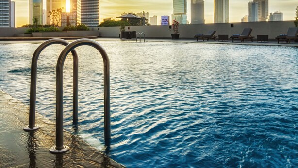 A swimming pool with a city skyline in the background. - Royal Kuningan Hotel (Jakarta)