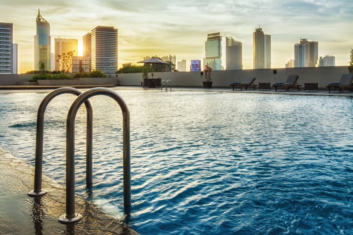 A swimming pool with a city skyline in the background.
