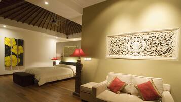 Ein Hotelzimmer mit Bett, Sofa, Nachttisch, Lampe und einer Wanddekoration.