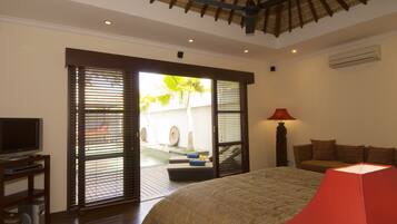 A bedroom with a bed, a TV, and a red lamp.